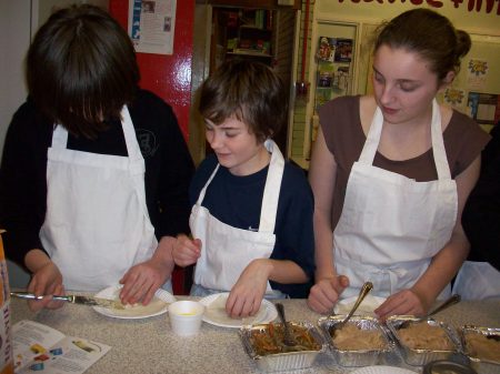 Three teenagers learning to cook Chinese dim sum at the Sweet Mandarin Chinese Cookery School with Lisa Tse